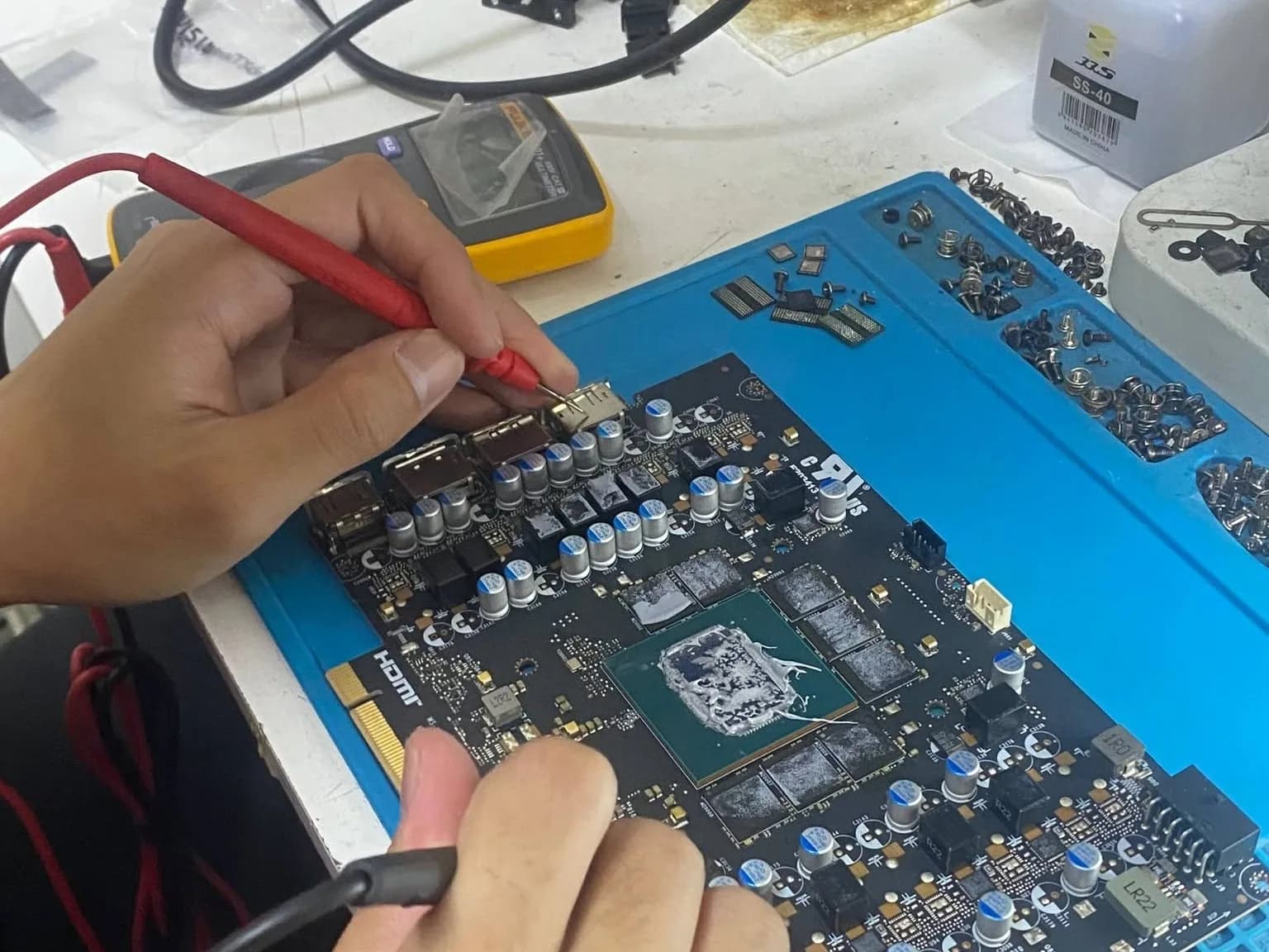 Technician measuring the power stage of a graphic card board