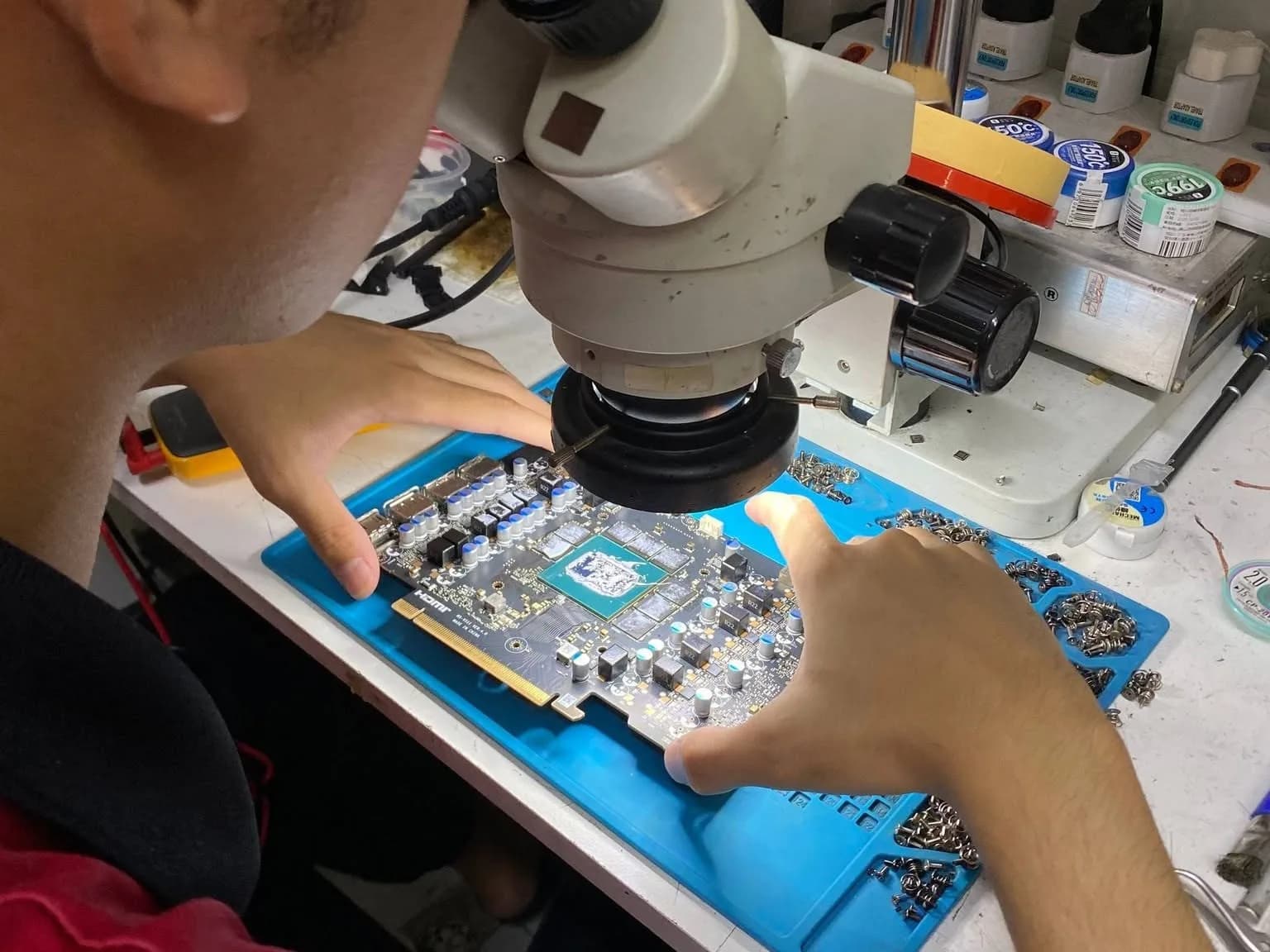 Technician inspecting a graphic card board under the microscope at SPR